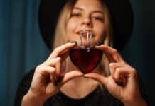 Cropped image of woman holding heart shaped glass jar of love potion