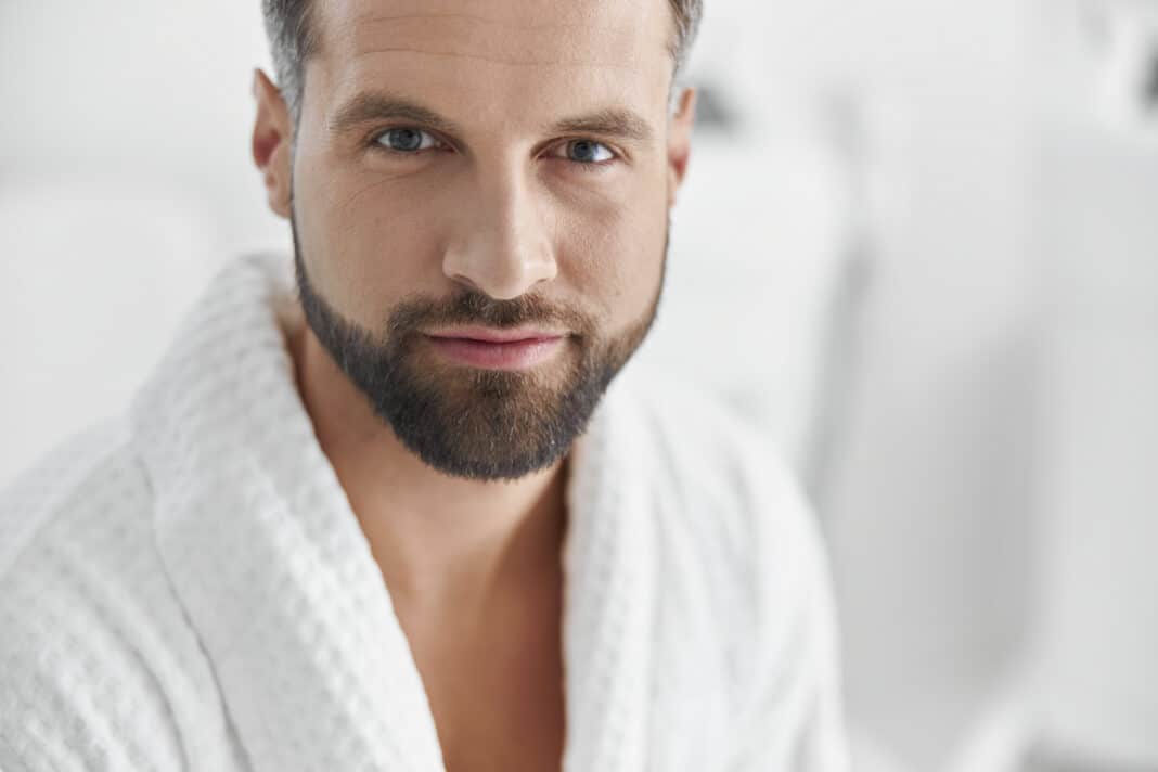 Positive man with styish waits for beauty procedures in cosmetologycal clinic