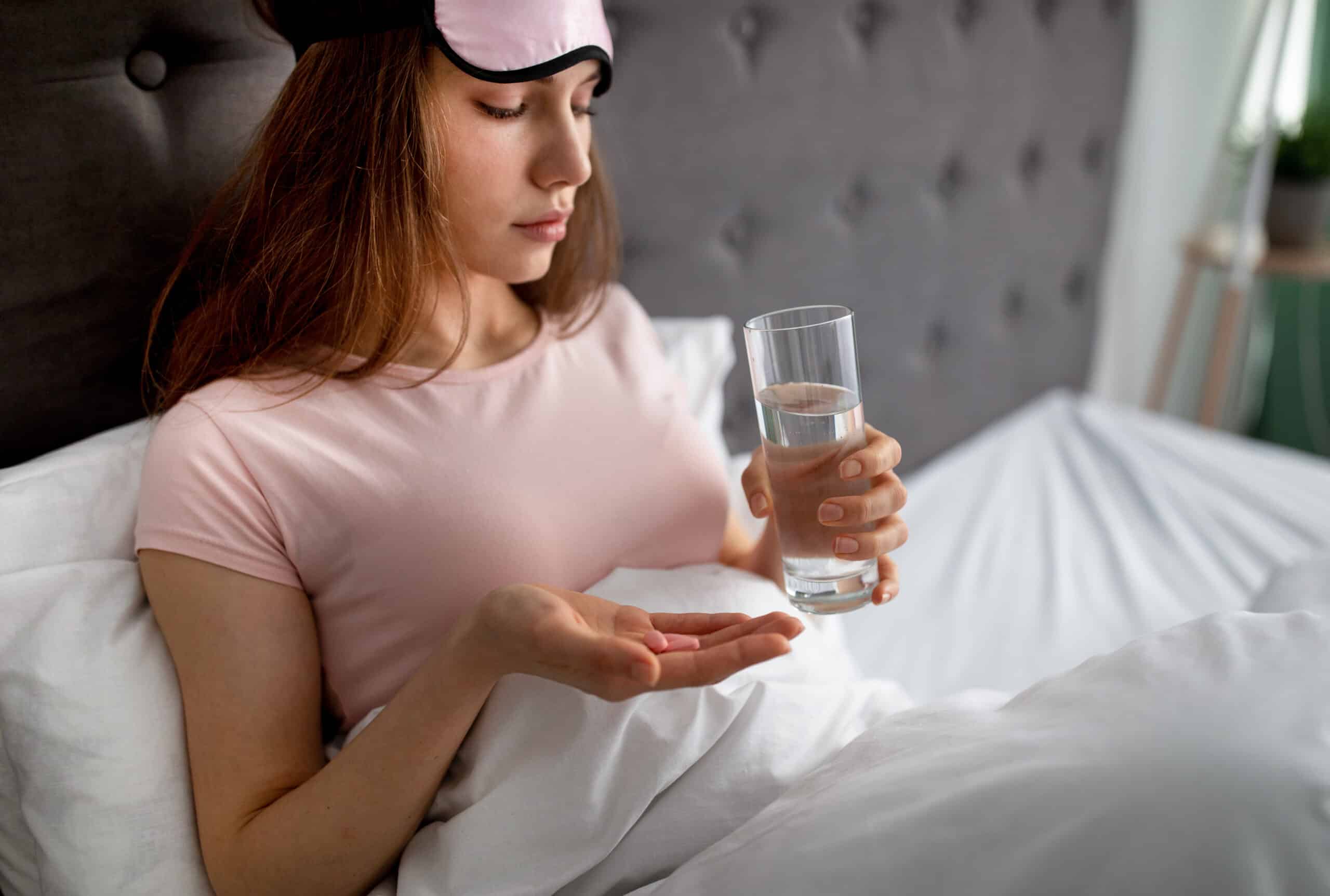 upset young woman sitting in bed with glass of wat 2022 12 16 07 31 48 utc scaled