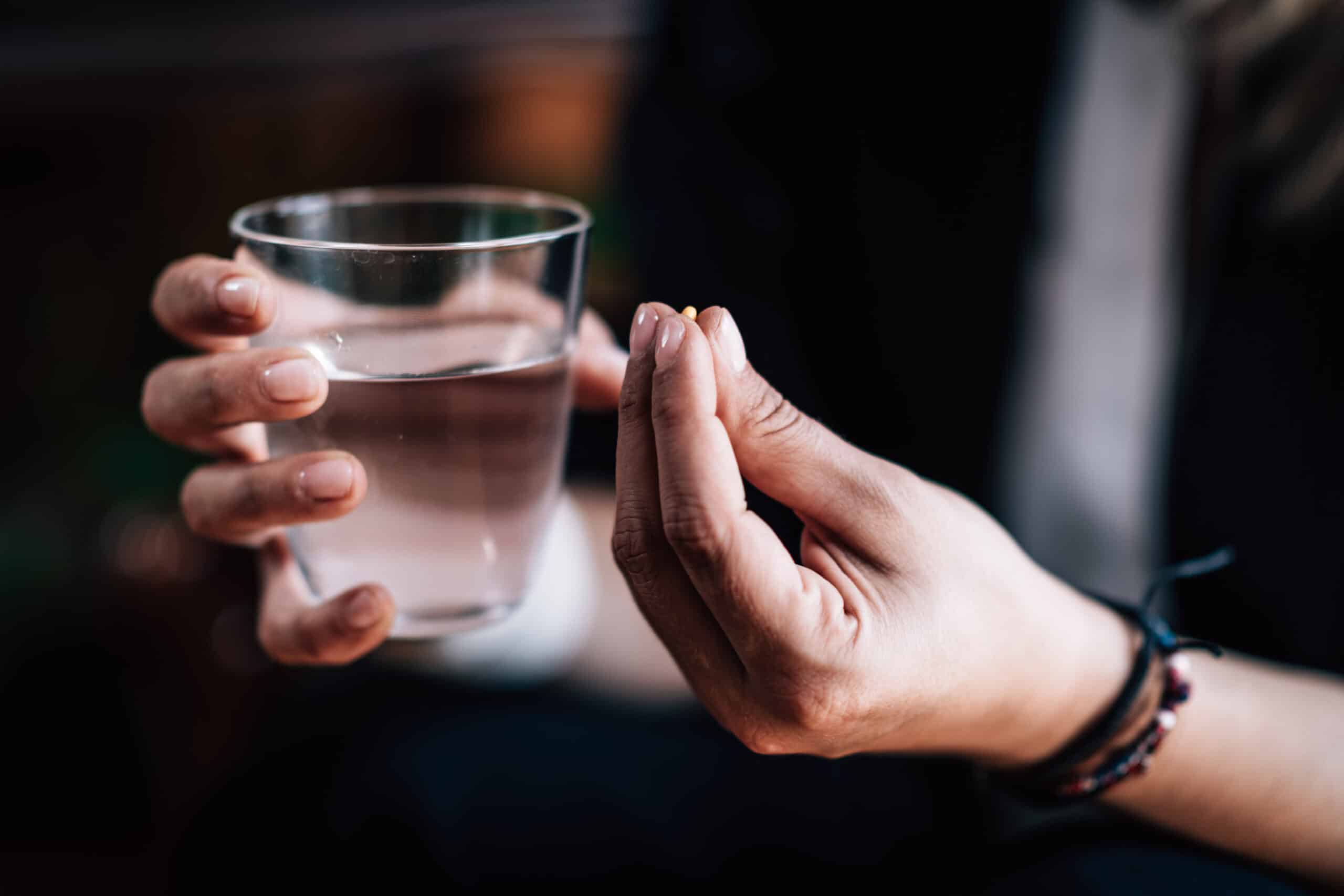 Woman with pills in hand.