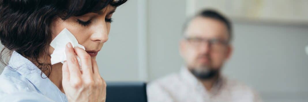 Beautiful woman wipes her tears while talking to the therapist