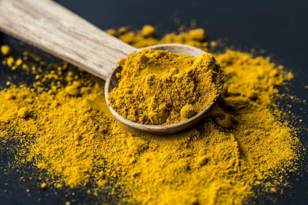 Closeup of tumeric powder spice on a spoon