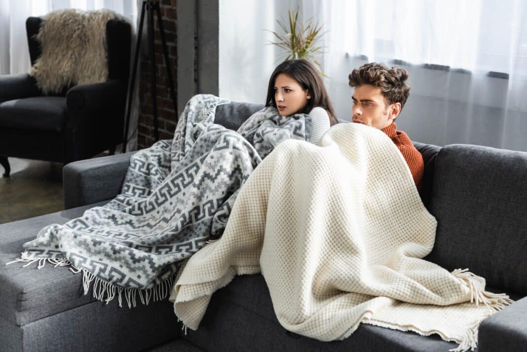 attractive girlfriend and boyfriend covered with blankest and feeling cold