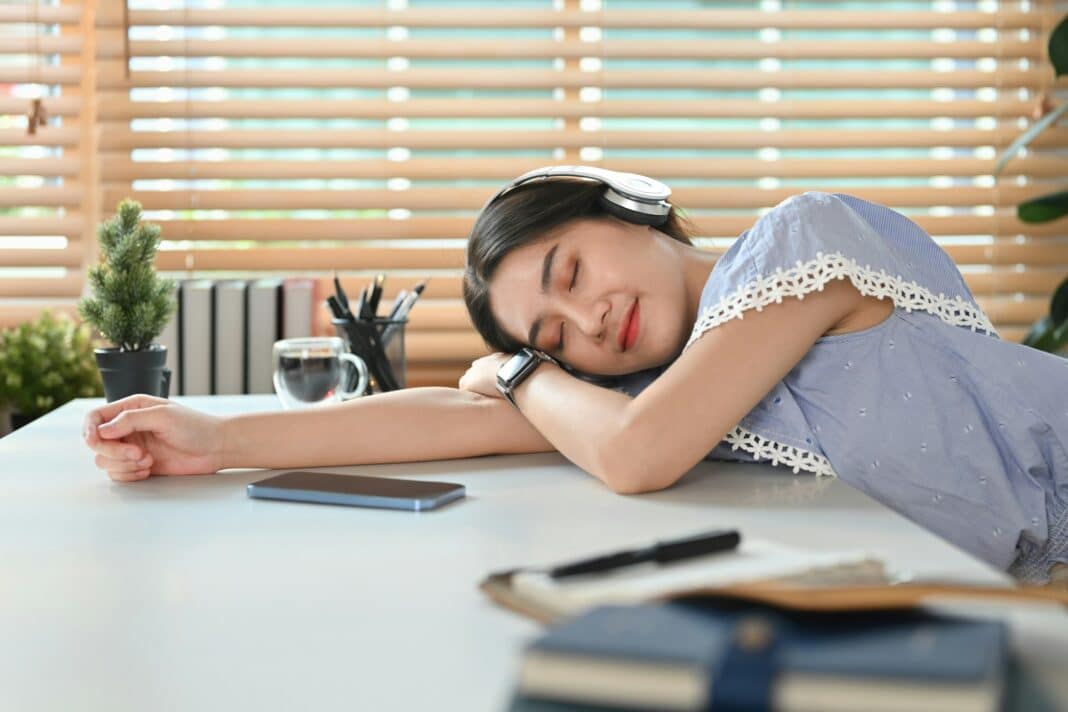 Pretty young asian woman sleeping at working desk.