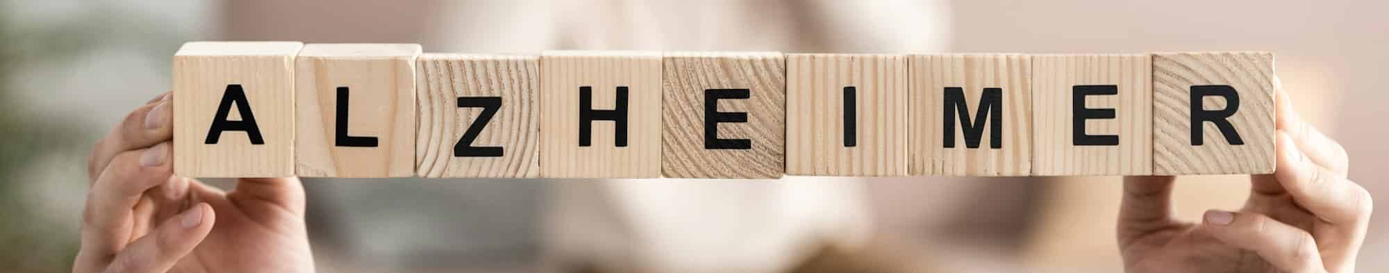 cropped view of senior woman holding wooden cubes with alzheimer letters