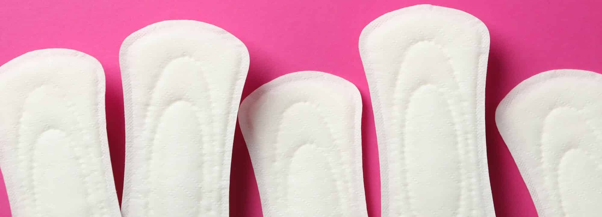 Sanitary pads frame on pink background, space for text